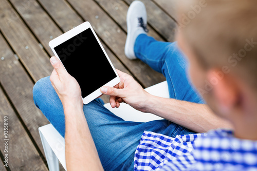 Relaxed man using digital tablet