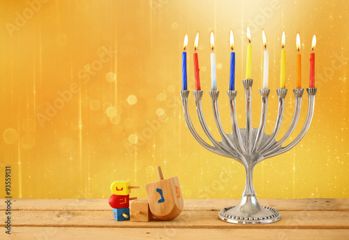 image of jewish holiday Hanukkah with menorah (traditional Candelabra) and wooden dreidels (spinning top). glitter background
