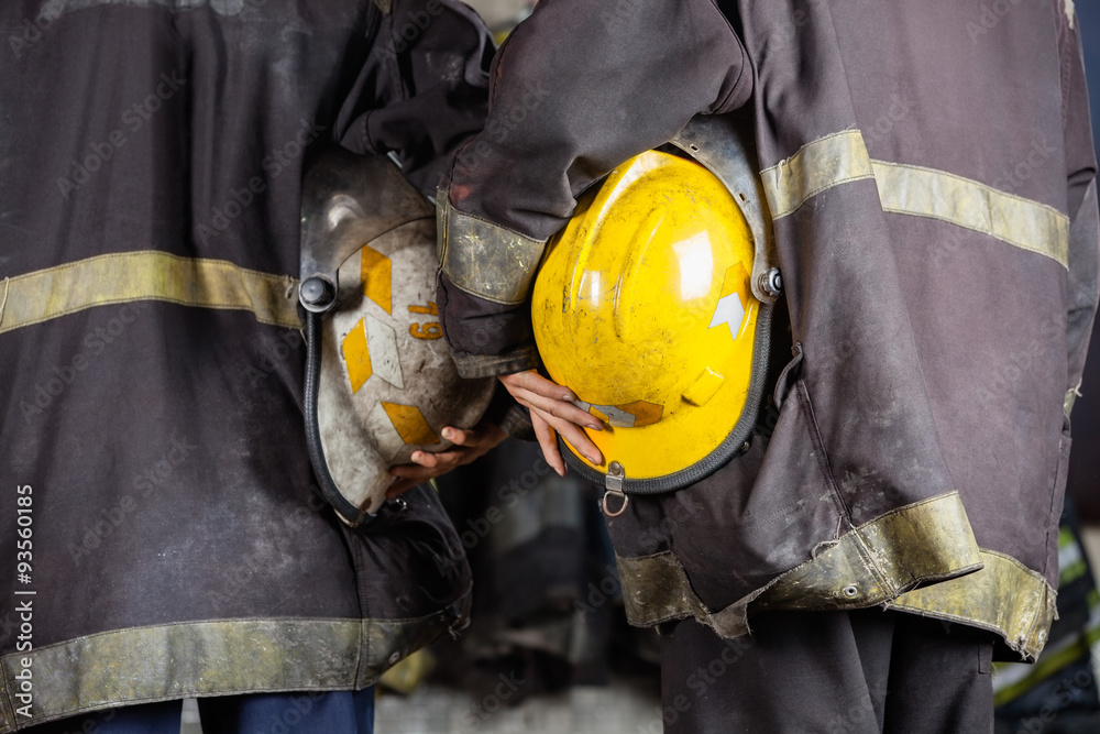 Fototapeta premium Workers Holding Helmets At Fire Station