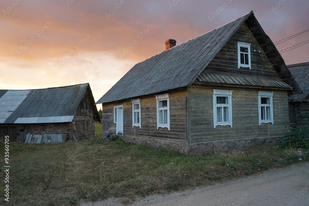 old wooden house in the village against sunset
