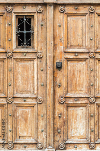 Ancient wooden door with iron grille © tomeyk