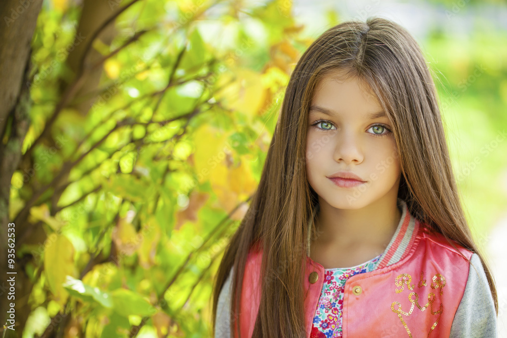 Beautiful little girl on green background of summer city park Beautiful little girl on green background of summer city park
