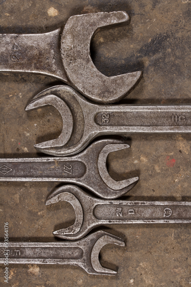 Set of wrenches on oiled floor of the garage Set of wrenches on oiled floor of the garage