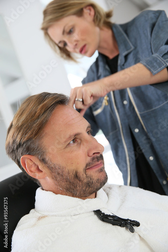 Middle-aged man having a haircut at hairdressing salon