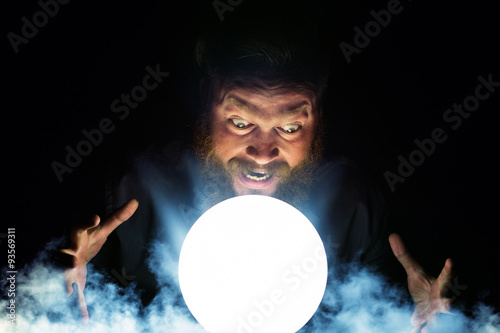 Obraz na plátně Dark wizard is making magic with the magic crystal.