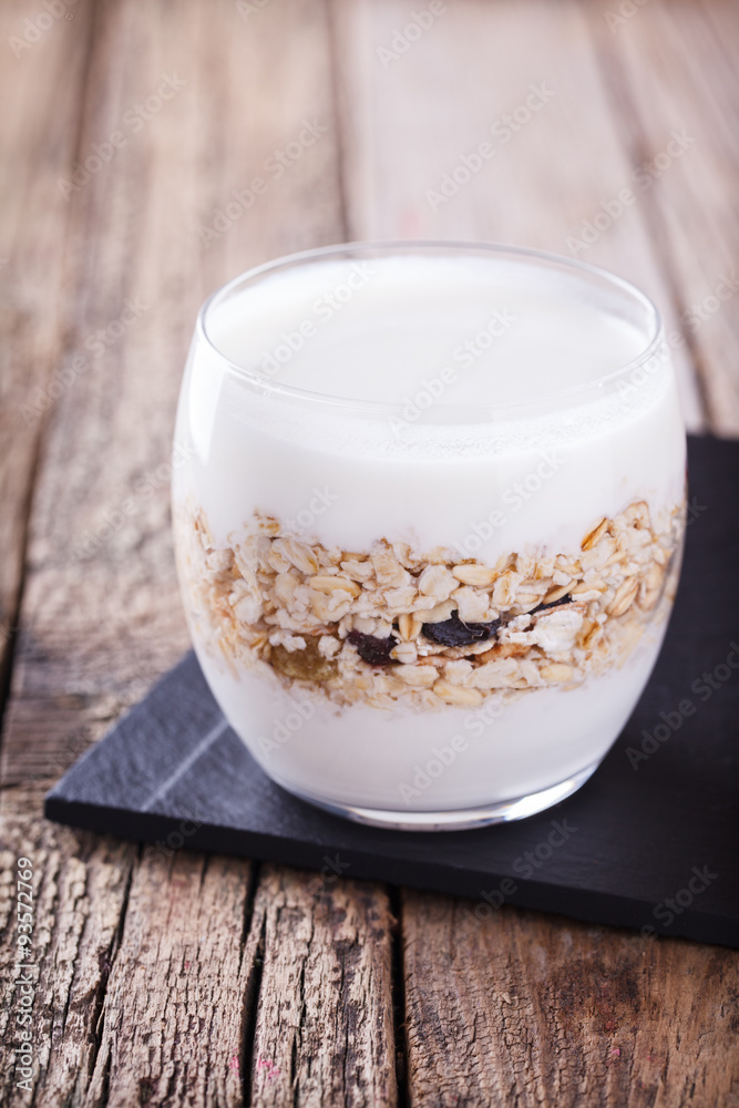 Breakfast with muesli, yogurt in a glass on a wooden background. selective focus Breakfast with muesli, yogurt in a glass on a wooden background. selective focus