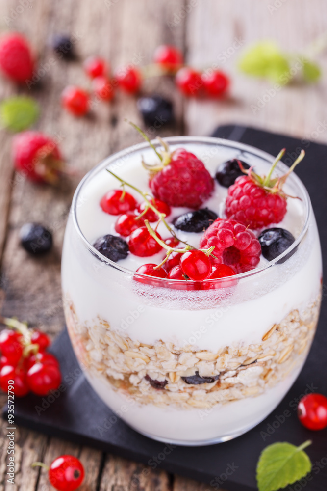 Breakfast with muesli, yogurt,honey and fresh berries in a glass on a wooden background. selective focus Breakfast with muesli, yogurt,honey and fresh berries in a glass on a wooden background. selective focus
