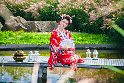 Foto Smiling woman in geisha costume in the garden