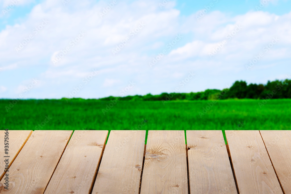 Wooden table with field background