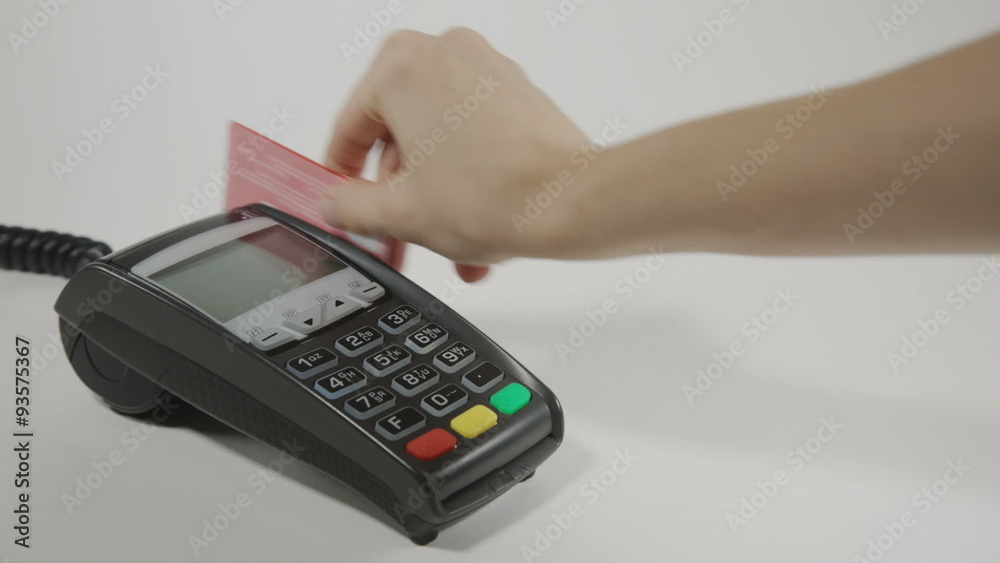 Hand swiping credit card on POS terminal Hand swiping credit card on POS terminal
