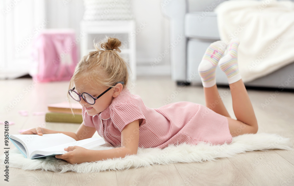Little girl reading book in the room Little girl reading book in the room