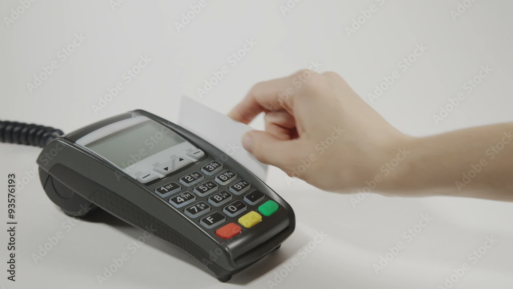 Hand swiping credit card on POS terminal Hand swiping credit card on POS terminal