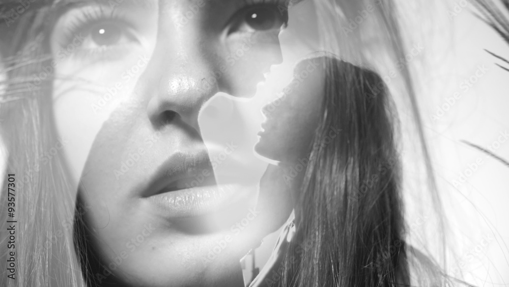 Woman uncovering eyes with double exposure of couple kissing