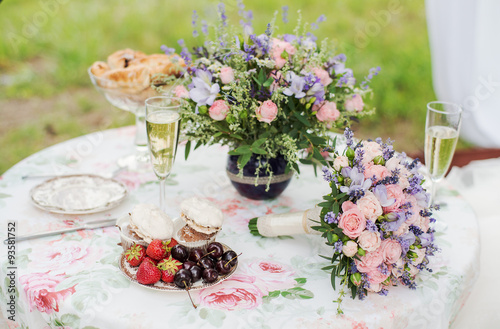 Fototapeta Naklejka Na Ścianę i Meble -  Served table outdoors. Flower arrangement with lavender and