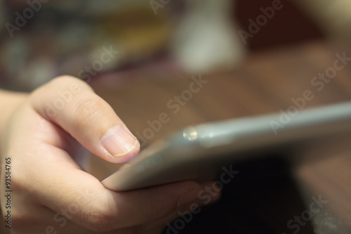 closeup woman hands using tablet computer on wooden table
