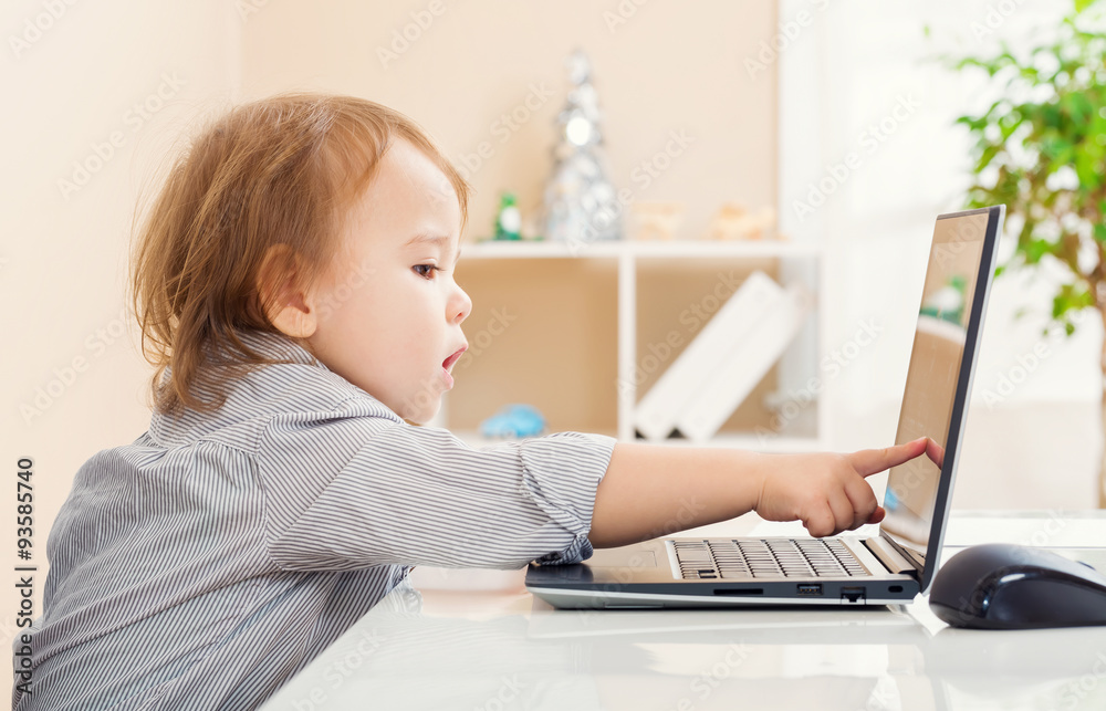 Toddler girl pointing to her laptop computer screen Toddler girl pointing to her laptop computer screen