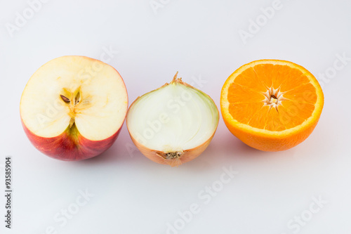 Cut fresh of apple, orange and onion on a white background/ half