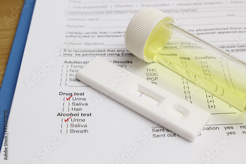 Drug test blank form with test kit and urine,focus on paper