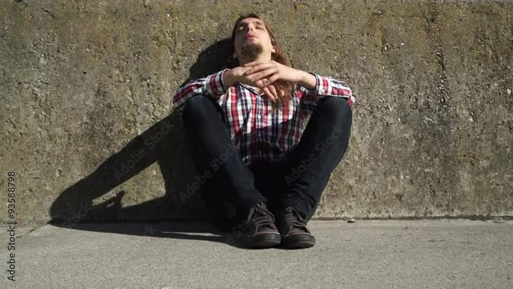 Man long haired sitting alone sad on grunge wall 4K Man long haired sitting alone sad on grunge wall 4K