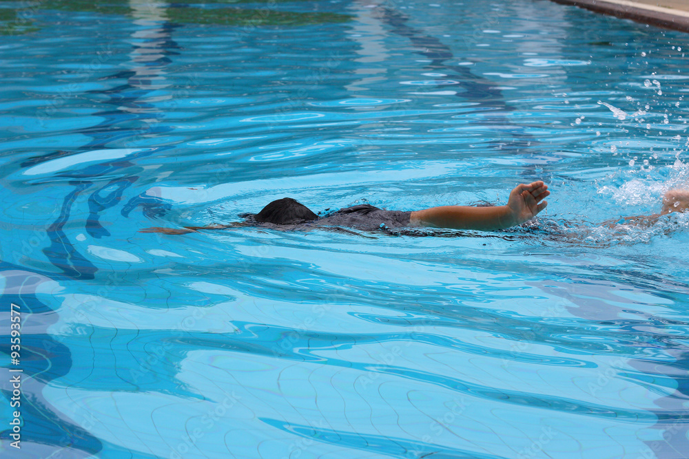 Obraz premium Swimming lessons / A kid learning his swimming lessons in action