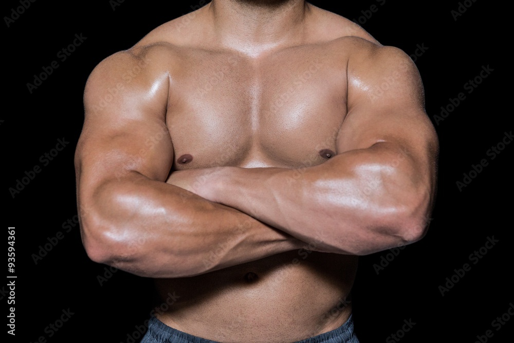 Mid section of a bodybuilder man with arms crossed