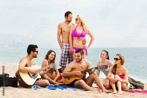 Adults with guitar at beach