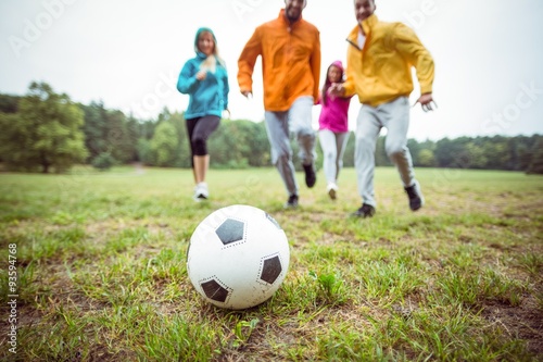 Friends running towards football