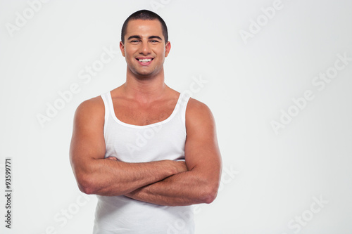 Canvas Print Happy muscular man standing with arms folded