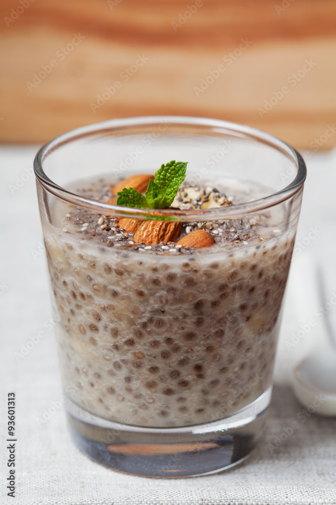 Chia seeds pudding with oat, banana and almonds decorated with mint leaves, vegetarian food Chia seeds pudding with oat, banana and almonds decorated with mint leaves, vegetarian food