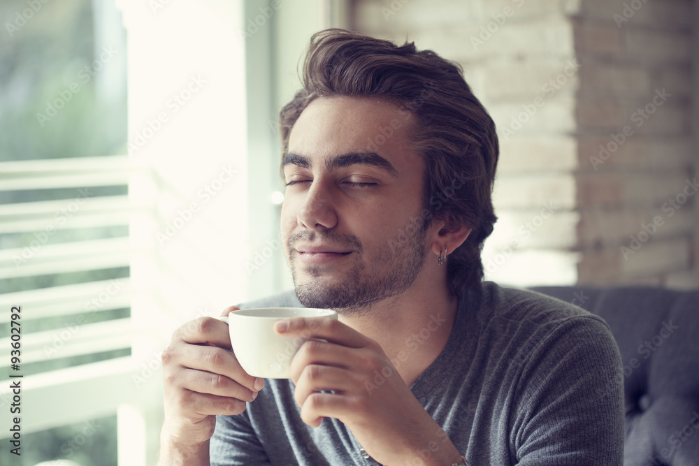 Young man drinking coffee in cafe Young man drinking coffee in cafe