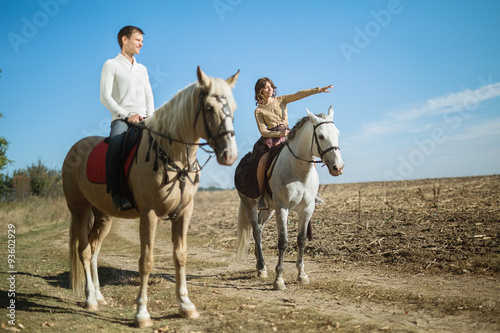 Young couple in love riding a horse
