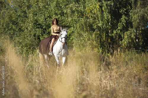 Beautiful girl riding a white horse © Andriy Bezuglov