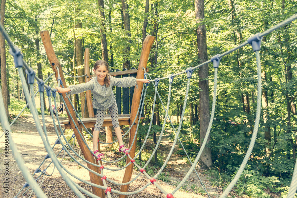 Fototapeta premium happy little girl in a rope park 