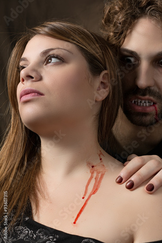 man vampire bites the neck of a woman