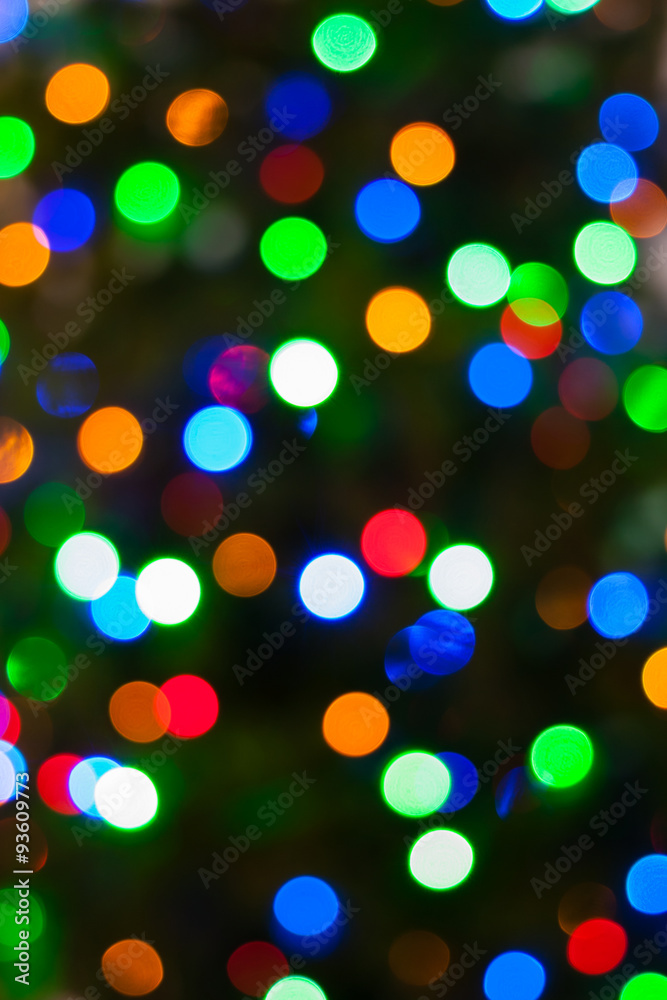 Colorful Christmas lights bokeh - A bright multicolor bokeh background created by a set of de-focused Christmas lights on a tree.