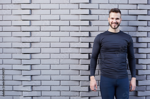 Portrait of smiling man resting after workout outdoors, fit caucasian