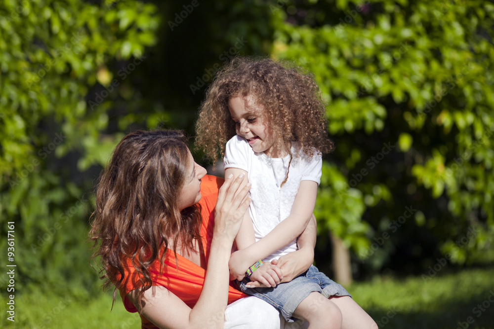 Mother and daughter are enjoying on grass at park Mother and daughter are enjoying on grass at park