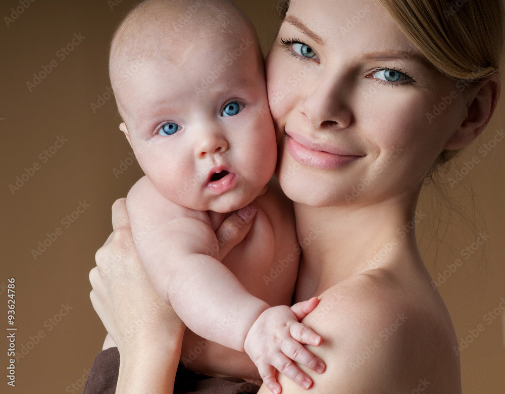 Young mother with a charming baby.Happy family. Mom's love and t Young mother with a charming baby.Happy family. Mom's love and t