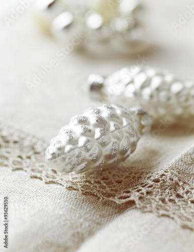 Silver cone-shaped Christmas ornaments on a linen table cloth