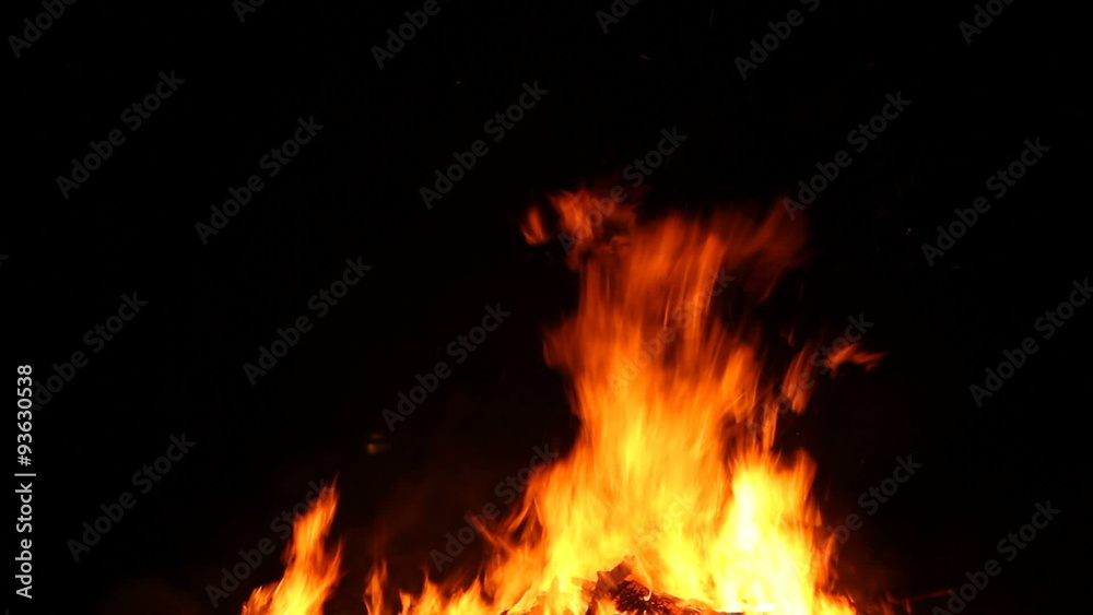 Wild yellow flames from a burning wood fire against a black background. Wild yellow flames from a burning wood fire against a black background.