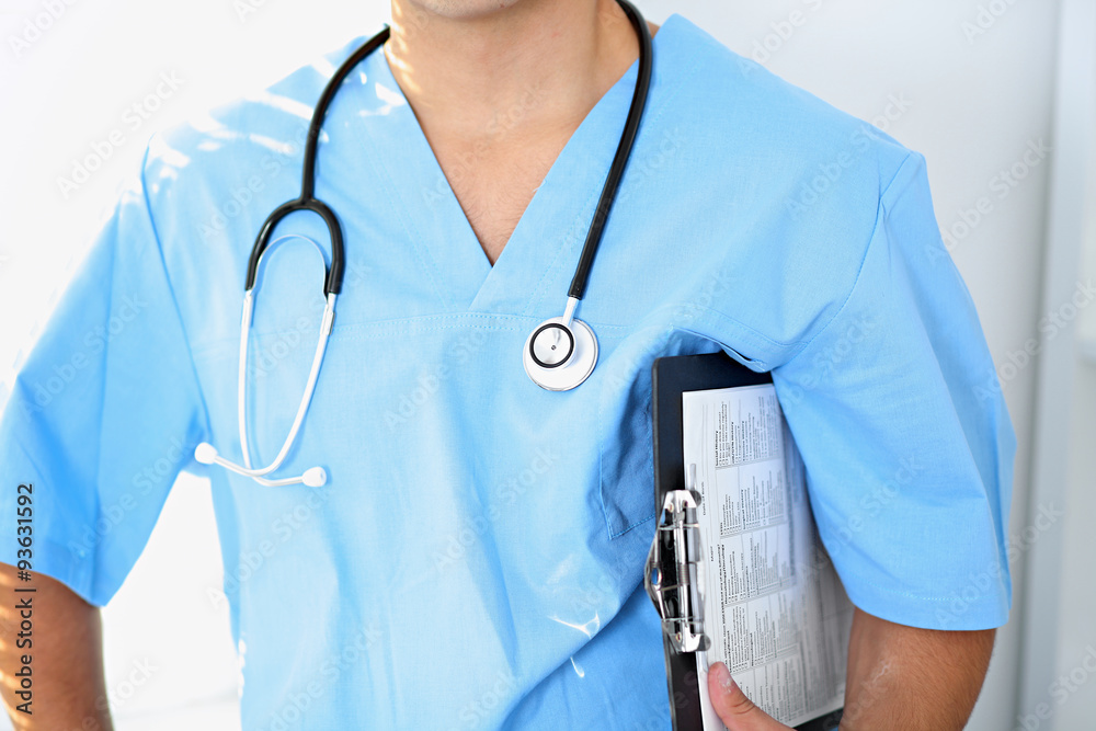 Portrait of unknown male surgeon doctor holding his stethoscope, crossed arms Portrait of unknown male surgeon doctor holding his stethoscope, crossed arms