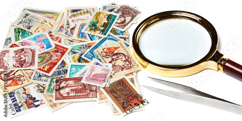 Old used postage stamps and magnifier