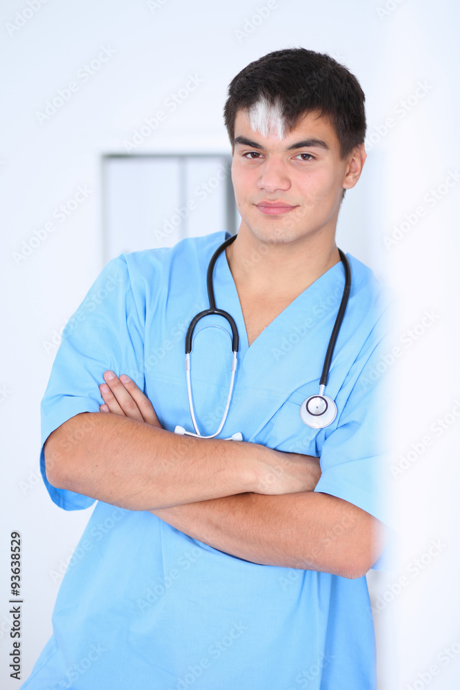 Portrait of unknown male surgeon doctor standing near the wall in hospital office Portrait of unknown male surgeon doctor standing near the wall in hospital office