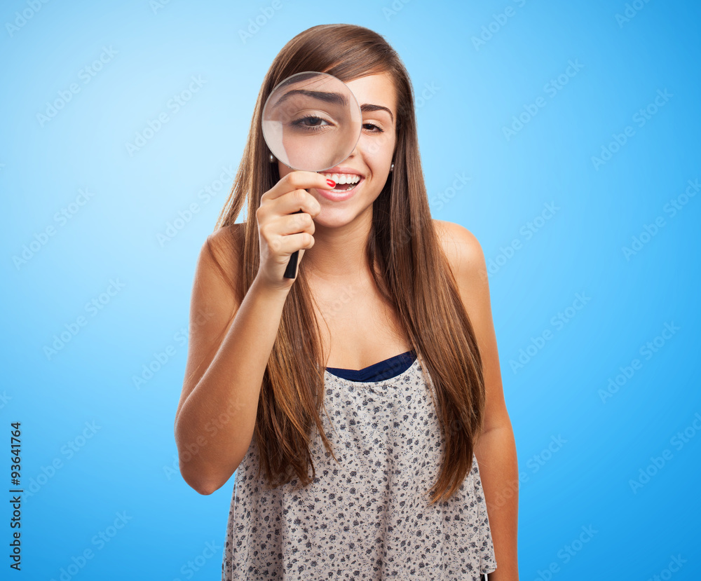 portrait of pretty young girl looking through a magnifying glass portrait of pretty young girl looking through a magnifying glass