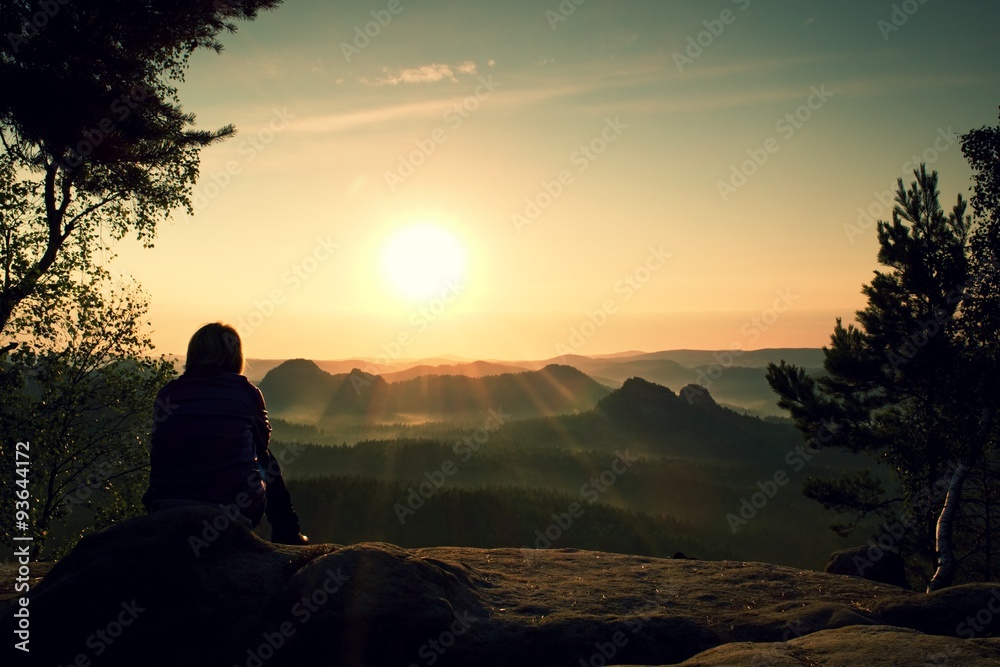 Young Woman hiker takes a rest bellow tree on peak of Mountain and enjoy autumn daybreak