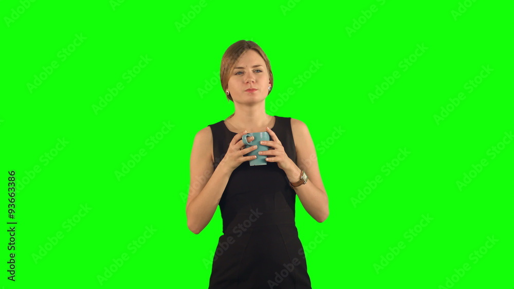 Young beautiful woman holding cup of tea or coffee on a Green Young beautiful woman holding cup of tea or coffee on a Green