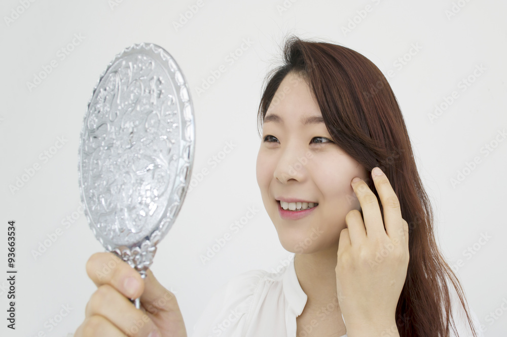 Pretty woman looking at herself in the mirror Pretty woman looking at herself in the mirror