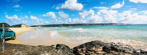 Canvas-taulu View of beach cove with rock platform and four wheel drive on a sunny day