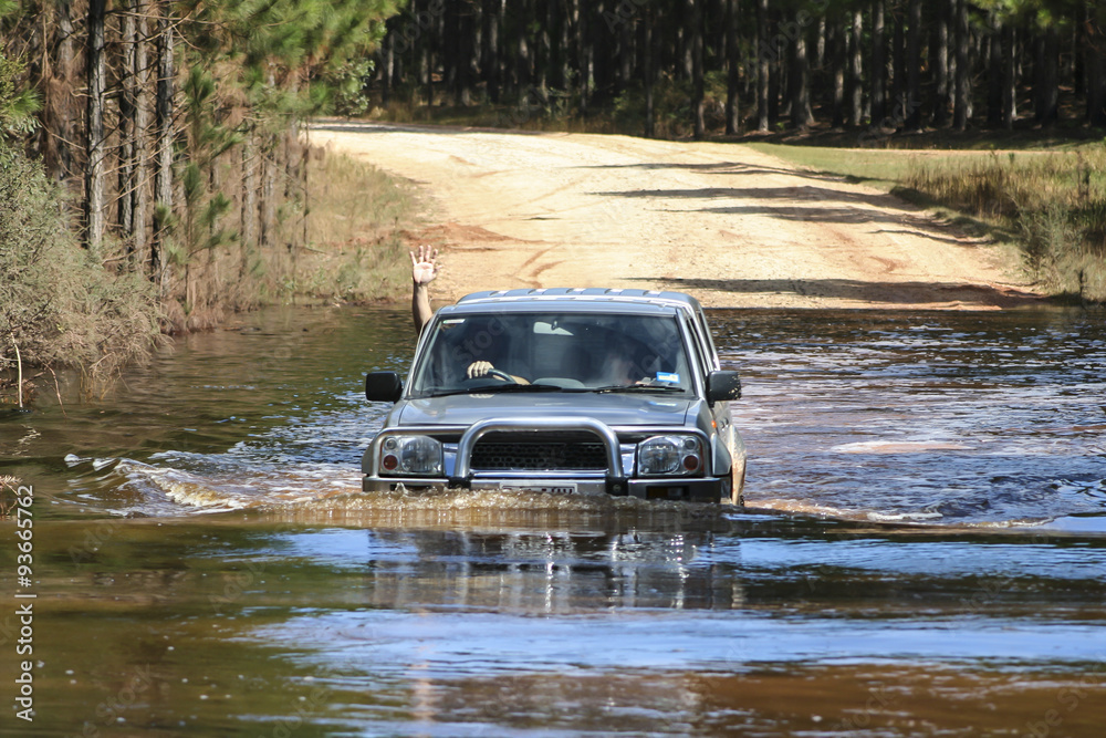 4x4 driver waving while crossing a driver over flood waters. 4x4 driver waving while crossing a driver over flood waters.