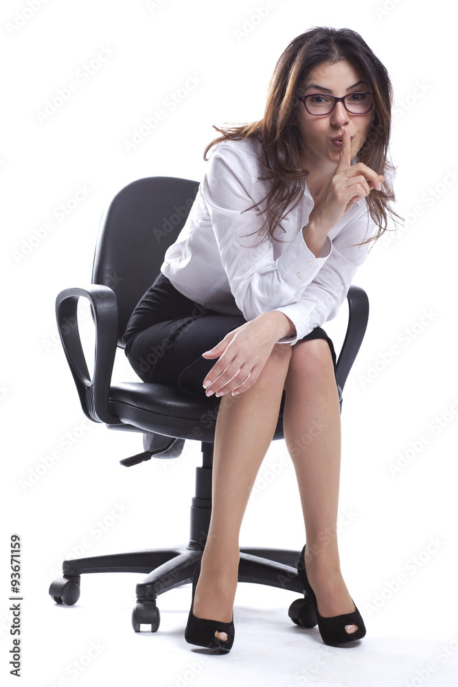Business woman is sitting and doing hush sign with glasses Business woman is sitting and doing hush sign with glasses